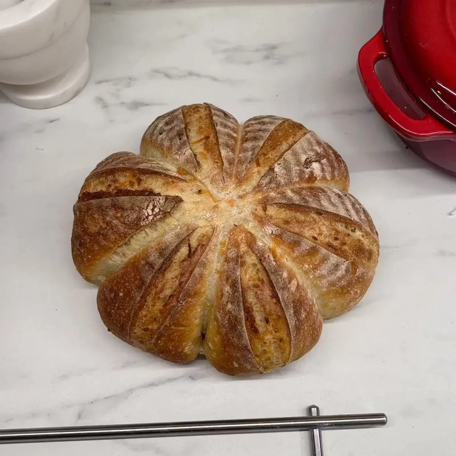 Kukkakuvioiseksi viilletty hapanjuurileipä Juulian Kotileipomon leivontapöydällä