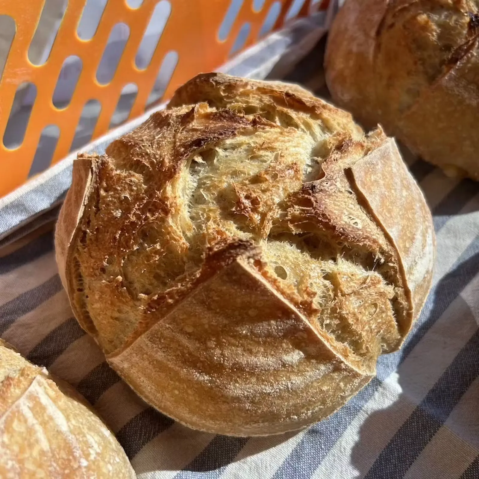Juulian Kotileipomon kaurainen hapanjuurileipä raidallisella liinalla