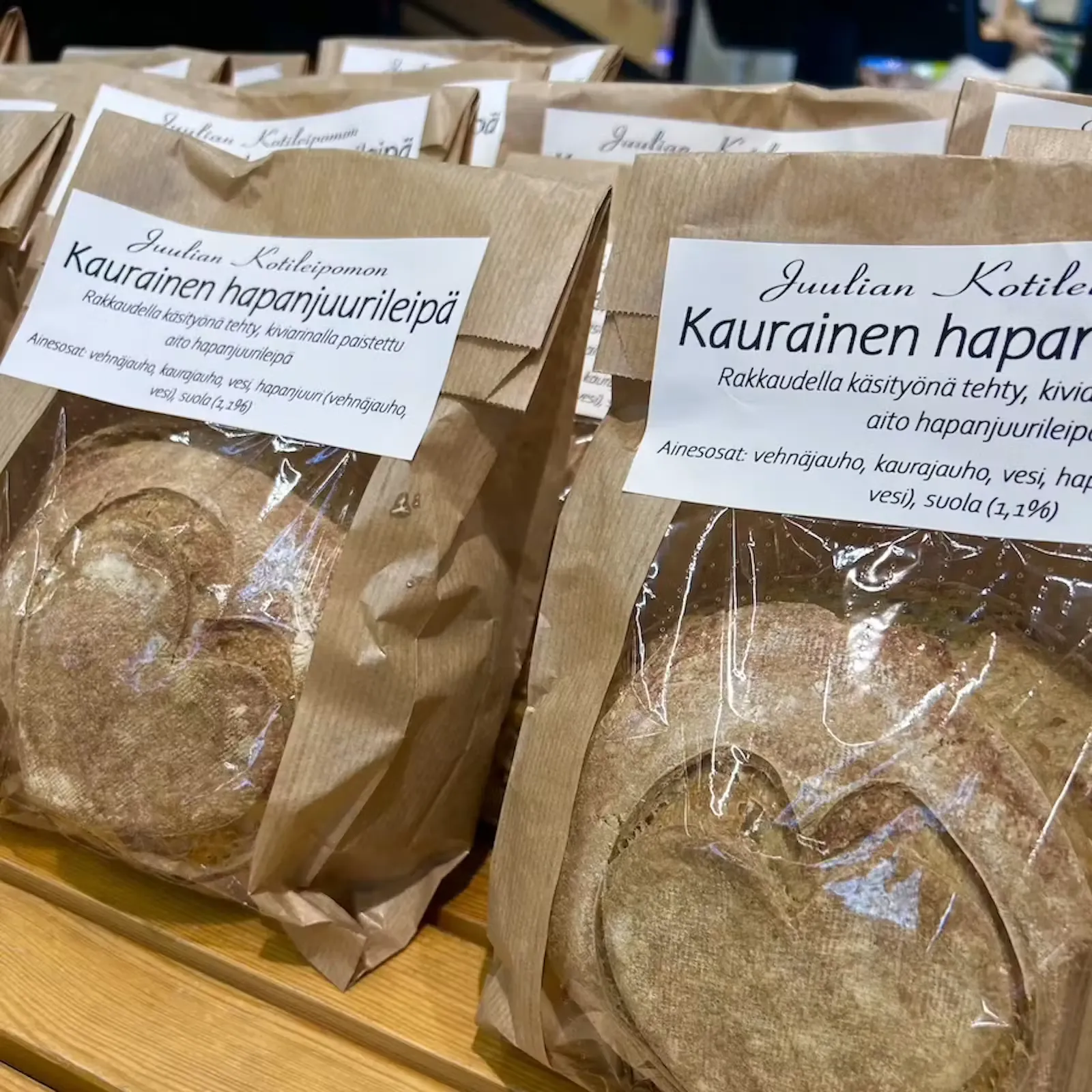 Juulian Kotileipomon kauraisen hapanjuurileivän paperipakkaukset myyntipöydällä